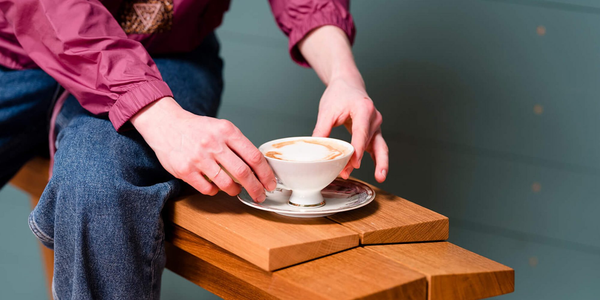 Eine Frau hält eine Tasse mit frischem Kaffee im Barbereich von Ruths Berlin